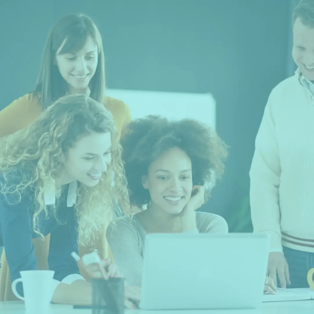 Group of people gathered around a computer to write a testimonial for Meticulous Bookkeeping, providing bookkeeping resources and services in Colorado Springs.