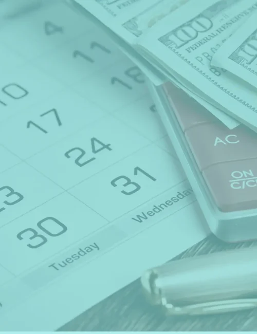 Monthly reconciliations represented by calendar, calculator and cash on a desk